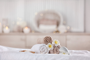 Towels and candles on massage table in modern spa salon. Place for relaxation
