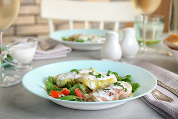 Plate with stuffed cabbage leaves and sour cream on table