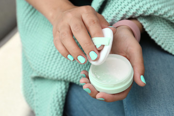 Young woman with stylish mint manicure holding powder, closeup