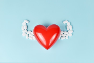 Red heart abstract concept with strong arms medicine on blue background.
