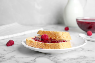 Tasty toasts with delicious raspberry jam on table