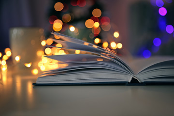 Open book and blurred Christmas tree on background