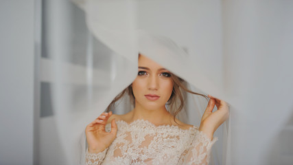 portrait of beautiful, sexy, elegant, brunette bride looks and posing under the veil