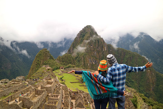 Couple admiring the spectacular view of Machu Picchu, UNESCO World Heritage site in Cusco Region, Urubamba Province, Peru