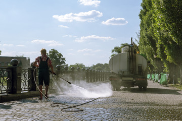 Work of municipal services. A woman washes the pavement
