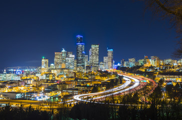 Obraz premium Pejzaż Seattle w nocy ze światłami na autostradzie, Waszyngton, USA.