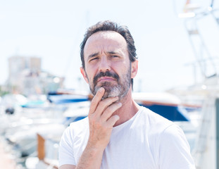 Handsome middle age man in marina serious face thinking about question, very confused idea