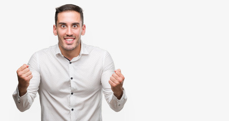 Handsome young business man screaming proud and celebrating victory and success very excited, cheering emotion