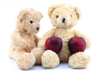 Teddy bear and red apple on a white background.