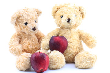 Teddy bear and red apple on a white background.