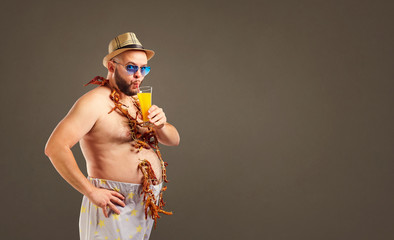 Funny fat bearded man with a glass of juice on holiday in the summer.