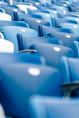 Multi-colored armchairs with numbers on a football stadium. Blue and white color.