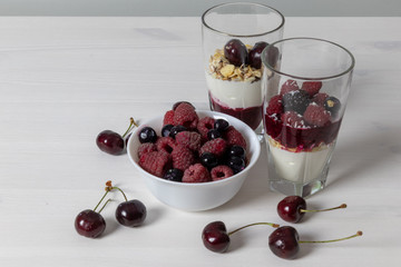 yoghurt with probiotic in a glass beaker with fruit on a light wooden table