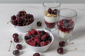 yoghurt with probiotic in a glass beaker with fruit on a light wooden table