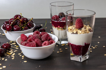 yoghurt with probiotic in a glass beaker with fruit on a dark wooden table
