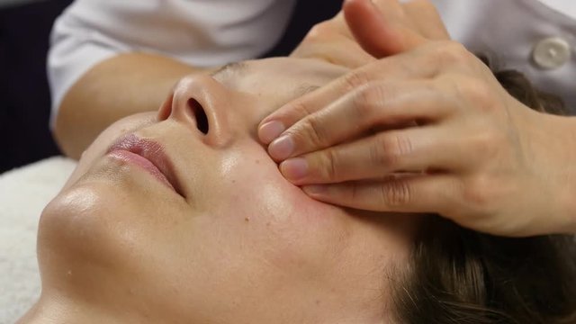 plastic face massage in spa saton. woman enjoys the services of a professional massage therapist. 4K