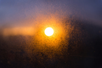 Blurred texture. Sunset after the rain through the glass with droplets. The evening sky.