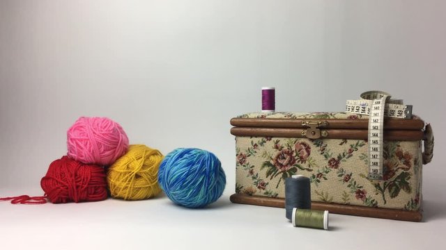 Escena de ovillo de lana rodando junto a objetos de costura.