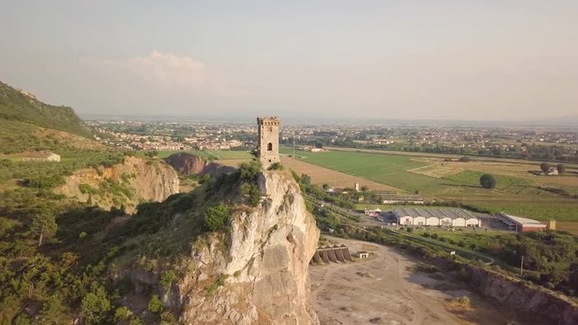 Piccola torre di un castello medievale su una rupe scoscesa. Torre di Caprona in provincia di Pisa. Vista aerea.