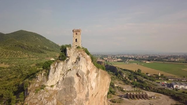 Piccola torre di un castello medievale su una rupe scoscesa. Torre di Caprona in provincia di Pisa. Vista aerea.