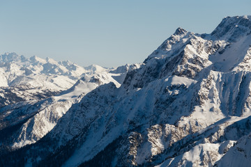Fototapeta na wymiar Steep slopes of the snowy mountain massif in Sochi, Russia
