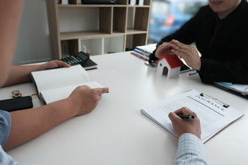 hand protecting house model. client signing home insurance contract. property safety & security...