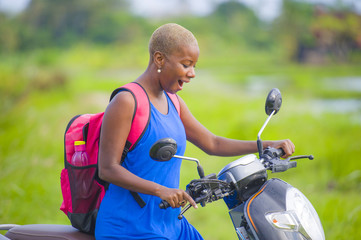 Fototapeta premium young attractive backpacker tourist afro American black woman riding motorbike happy in beautiful Asia countryside along green rice fields smiling