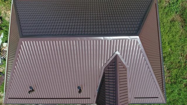Roofing of metal profile wavy shape. The roof of corrugated sheet. A view from above on the roof of the house