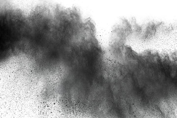 Black powder explosion against white background.Closeup of black dust particles explode isolated on white background.