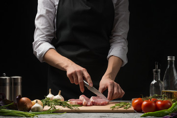 Sliced meat chef. A man is cooking a steak and a vegetable garnish. On a background of vegetables,...