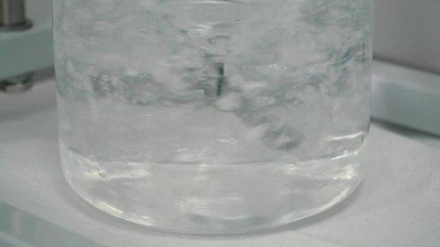 Liquid with flakes mixing with a blender in laboratory