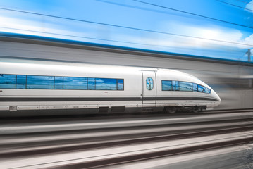 Obraz premium Szybki pociąg pędzi przez miasto koleją