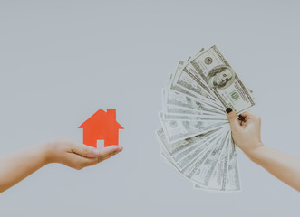 holding house representing home ownership and the Real Estate business.