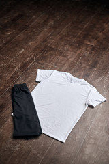 White shirt with black shorts on wooden floor