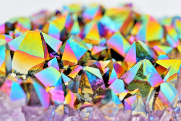 Amazing colorful flashing Amethyst Quartz Rainbow Titanium Aura Crystal cluster closeup with shallow depth of field isolated on white background. Macro of beautiful rare sparkly rainbow mineral stone