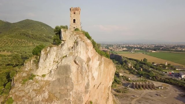 Piccola torre di un castello medievale su una rupe scoscesa. Torre di Caprona in provincia di Pisa. Vista aerea.