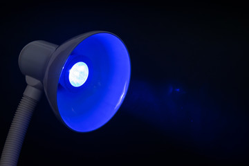 table lamp with blue diode bulb on black background