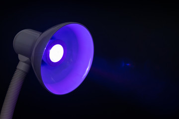 table lamp with purple diode bulb on black background