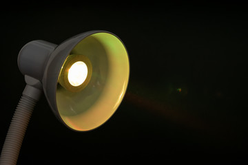 table lamp with yellow diode bulb on black background