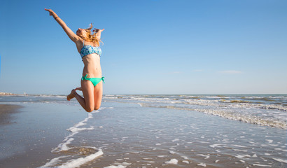 beautiful woman jump on the beach in the sea
