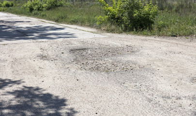 bad asphalt road, pit on the road
