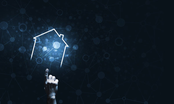 Conceptual image with hand pointing at house or main page icon on dark background