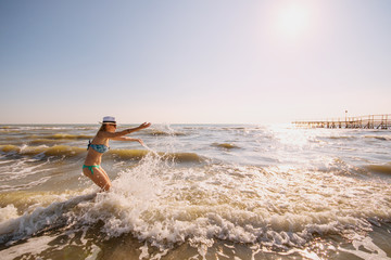 Fototapeta na wymiar beautiful woman play with the water of the sea