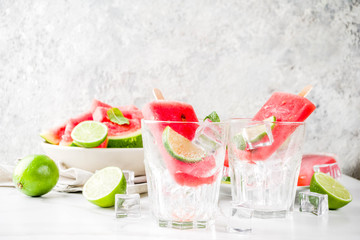 Sweet summer watermelon and lime popsicles with sliced watermelon and mint, on white marble background copy space