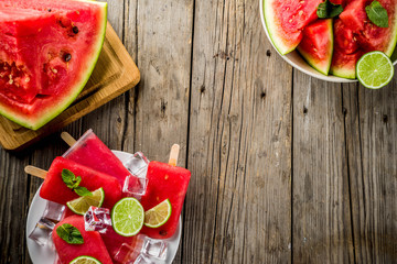 Sweet summer watermelon and lime popsicles with sliced watermelon and mint, on white marble background copy space