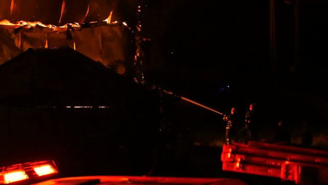 Firefighters Spraying Water At A Warehouse