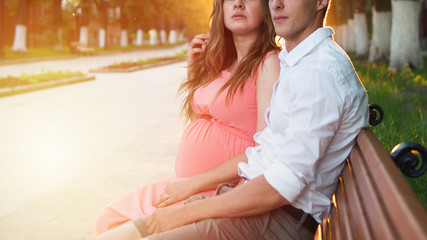 Married pregnant couple resting in the Park