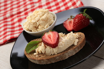 Slices of bread with white cheese and strawberries on top