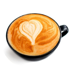 Cappuccino in a black coffee cup isolated on white background, close up. Hot coffee with milk foam with heart shape.
