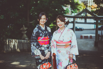 Fototapeta na wymiar Two japanese girls wearing kimonos traditional clothes, lifestyle moments